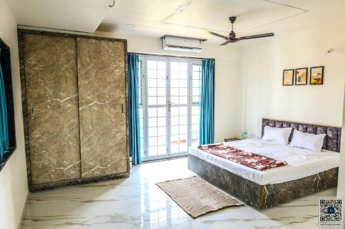 a bedroom with a large bed and a large window at Vista Bliss 3BHK Villa With Private Pool in Igatpuri