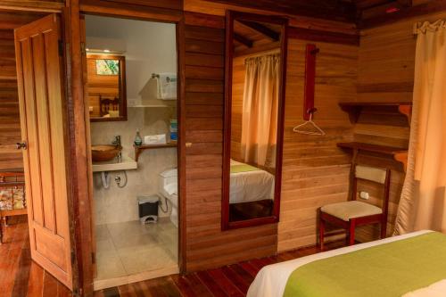 a room with a bedroom with a bed and a mirror at Cabañas Germany in Puyo