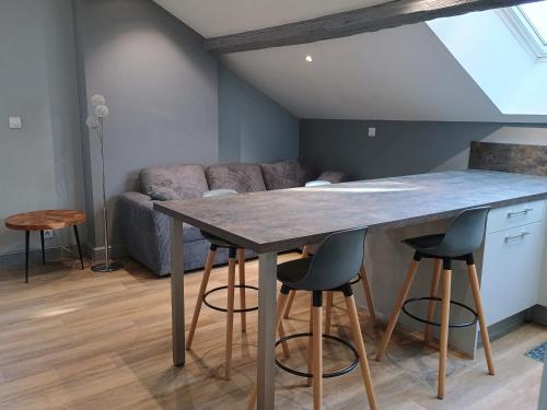 une cuisine avec une table et des tabourets dans une pièce dans l'établissement Appartement de charme à Amboise face à la Loire, à Amboise