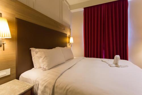 a hotel room with a bed with a teddy bear on it at 麗馨商旅七賢館 in Kaohsiung
