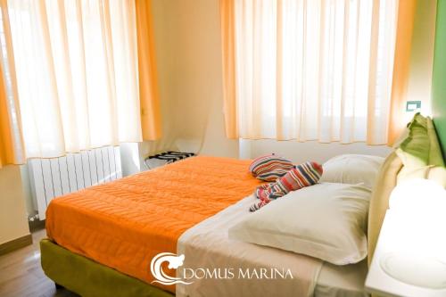 a bedroom with a bed with an orange blanket at Domus Marina - Egeo Apartment in Mondragone