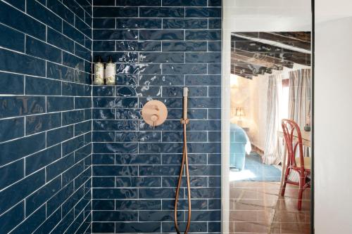 a blue tiled wall with a shower in a room at Cortijo Genesis in Gaucín