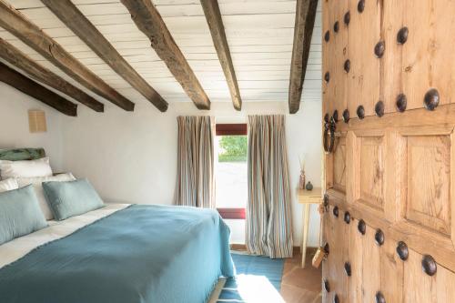 a bedroom with a bed and a wooden wall at Cortijo Genesis in Gaucín