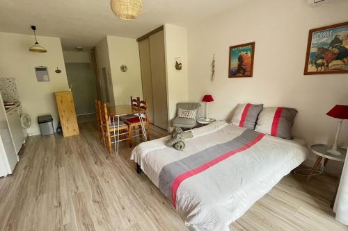 une chambre avec un lit, une table et des chaises dans l'établissement Appartement Moriani plage, à San-Nicolao