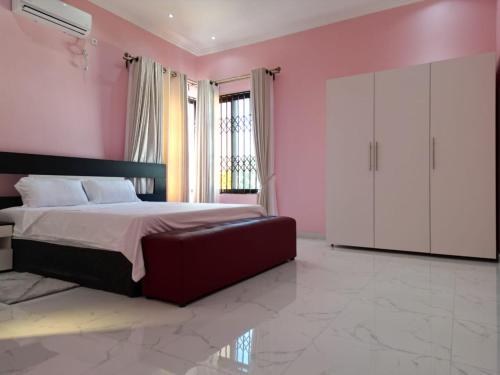 a bedroom with a large bed and pink walls at M Square in Ponta do Ouro
