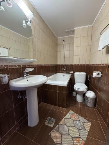 a bathroom with a sink and a tub and a toilet at Hotel Golden Beach in Eforie Nord