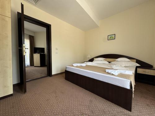 a bedroom with a large bed with a large mirror at Hotel Golden Beach in Eforie Nord