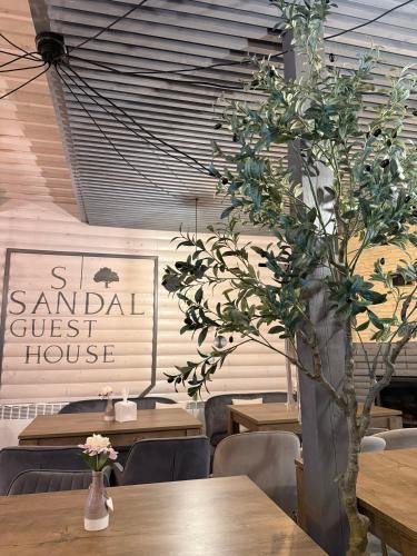 a dining room with tables and a vase with a plant at Sandal in Shaian