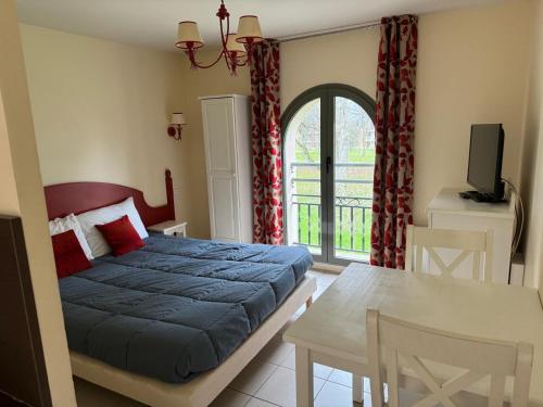 une chambre avec un lit, une table et une télévision dans l'établissement Goélia Résidence Du Parc, à Gonneville-sur-Honfleur