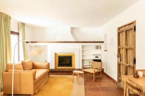 a living room with a couch and a fireplace at Cortijo Genesis in Gaucín