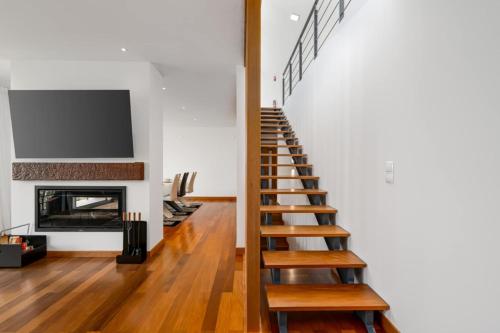 a staircase in a living room with a fireplace at villa vista do vale in São Vicente