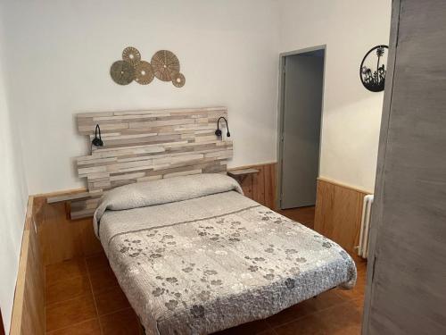 ein Schlafzimmer mit einem Bett und einer Holzwand in der Unterkunft Mallona in Pedro Rodríguez