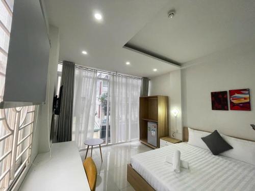 Un dormitorio con una cama y una ventana grande. en Atusy Boutique Hotel, en Ho Chi Minh