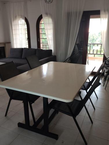 a white table in a living room with a couch at Villa Panorama in Mola Kalyva