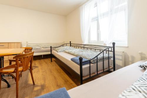 a bedroom with two bunk beds and a table at Hostel u Arény in Ostrava