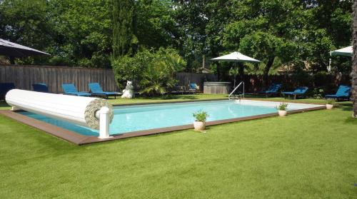 a swimming pool with a slide in a yard at Villa Herbert Maison d'Hôtes in Andernos-les-Bains