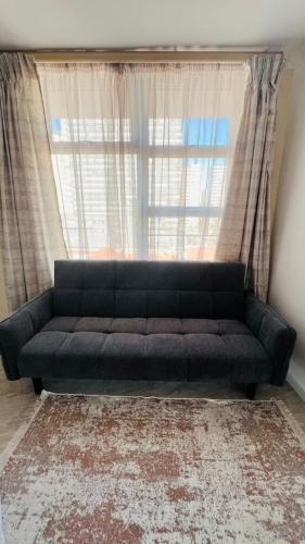 a black couch sitting in front of a window at The oceanic 48 in Durban