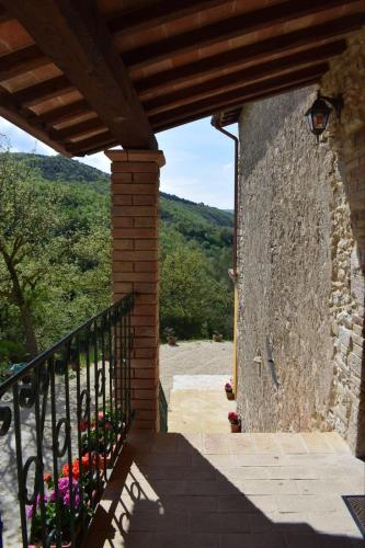 a stone wall with flowers on the side of a building at Agriturismo Le Rocchette in Rocchette