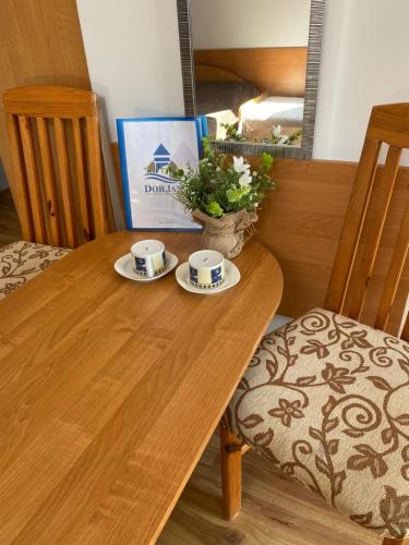 a wooden table with two cups of coffee on it at DorJan - Pokoje Gościnne in Dziwnówek