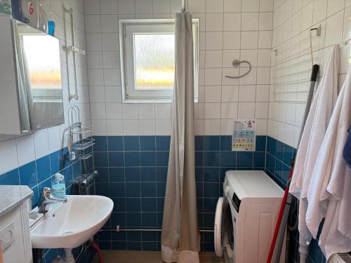 a blue and white bathroom with a sink and a toilet at Apartment in South West Stockholm w Balcony near Metro, convenient to Avicii Arena, 3 Arena, Friends Arena and Royal Opera in Stockholm