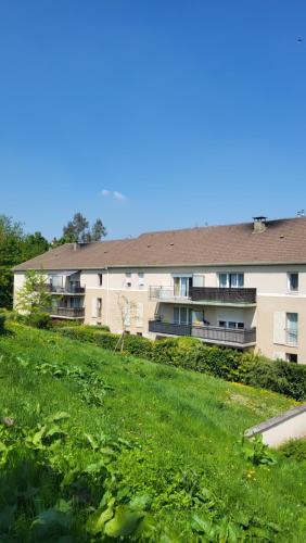 un immeuble d'appartements avec un champ vert en face de celui-ci dans l'établissement B&B Sweet Meauxtown - Gare de Meaux, à Villenoy