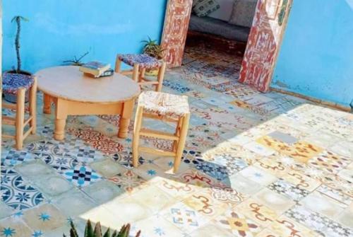 a room with a table and chairs on a tile floor at Dar safa in Essaouira