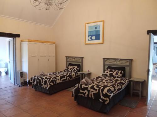a bedroom with two beds in a room at The Retreat Country Lodge in Romelcoh