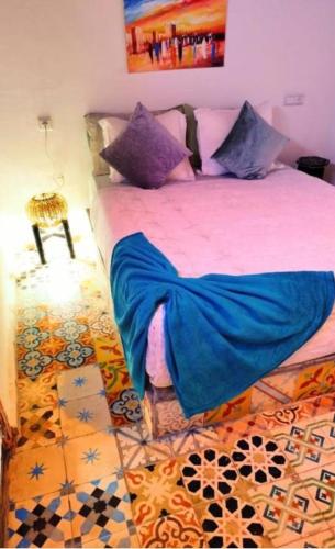 a bedroom with a large bed with blue sheets at Dar safa in Essaouira