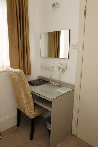 a desk with a mirror and a chair in a room at Maples House Hotel in Dublin