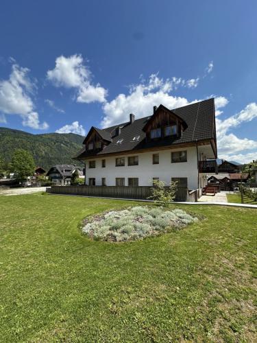 a large white house with a large yard at Apartments Vršič on the ski slope with free parking in Kranjska Gora