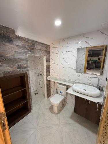 a bathroom with a toilet and a sink at Villa piscine Saïdia 3 chambres in Saidia 