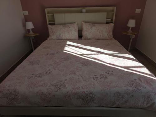 a bedroom with a bed with a pink comforter at B612 bed & breakfast CAMERE in Manoppello
