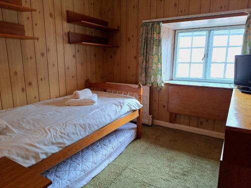 a bedroom with a bed in a room with a window at House in historic village - Sleeps 6 in Minehead