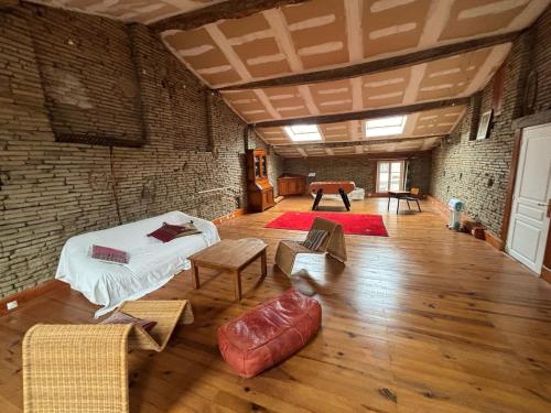 Cette grande chambre dispose d'un lit et d'un mur en briques. dans l'établissement Belle maison de Village, à Baziège