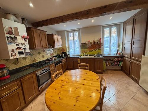 - une cuisine avec une table et des chaises en bois dans l'établissement Belle maison de Village, à Baziège