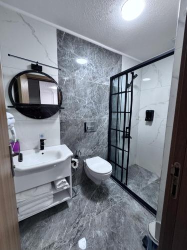Un baño con un inodoro blanco y un lavabo. en Solaklı Pansiyon, en Uzungöl