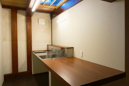 a kitchen with a sink and a wooden counter top at 泊まれる文化交流施設 盆宿U bon-yadoU in Nishimonai