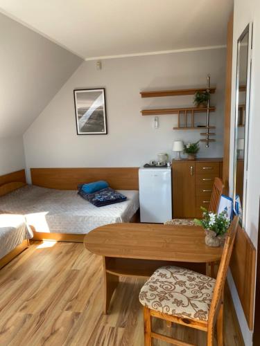 a small room with a bed and a table at DorJan - Pokoje Gościnne in Dziwnówek