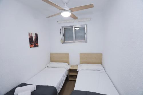 2 camas en una habitación con ventilador de techo en DIFFERENTFLATS Dms, en La Pineda
