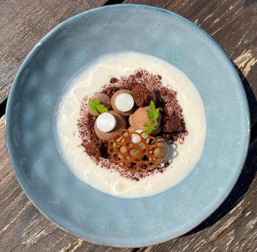 a blue plate with a dessert with eggs and nuts at Auberge du Relais d'Auniac - Hôtel Bar Restaurant Piscine in Anglars-Nozac