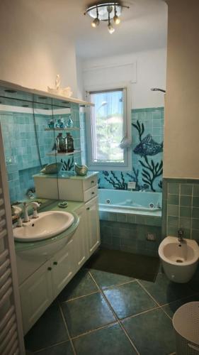 une salle de bain avec un lavabo, une baignoire et des toilettes dans l'établissement karine et thierry, à Arles