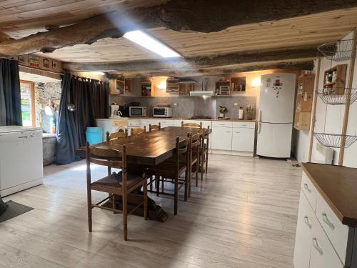 a kitchen with a table and chairs and a refrigerator at L'abri de rioumaou in Saligos