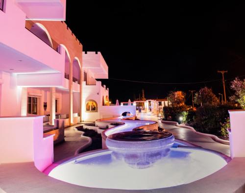a building with a large fountain in a courtyard at night at Castello Di Cavallieri Suites & Spa - Adults Only in Faliraki