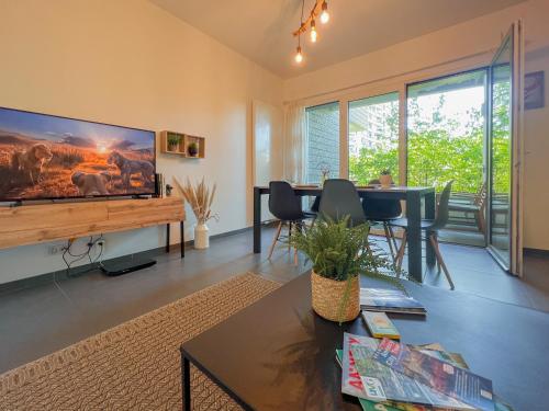 un salon avec une grande télévision à écran plat dans l'établissement Eldorado proche du lac, à Annecy