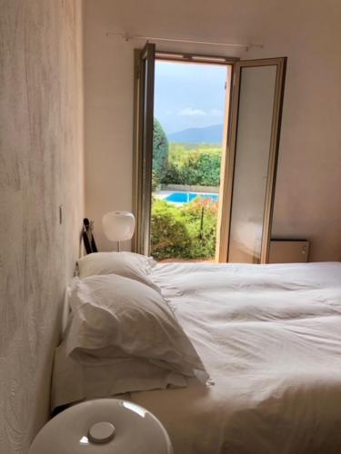 une chambre avec un lit blanc et une fenêtre dans l'établissement Villa familiale dans beau domaine, à Villeneuve-Loubet