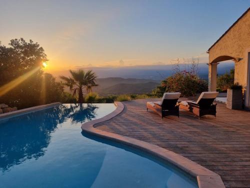 - une piscine avec 2 chaises et un coucher de soleil dans l'établissement Beautiful villa close to beach, great views & pool, à Les Adrets-de-l'Estérel