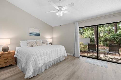 a white bedroom with a bed and a large window at Beach and Golf Adventures 3 Bedroom Sleeps 6 in Pawleys Island