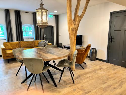 a dining room with a wooden table and chairs at Vakantiewoning Korenburgerveen 't Voorde in Winterswijk