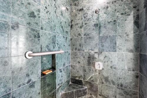 a bathroom with a shower with blue tiles at Mauna Lani Villages 606 in Waikoloa