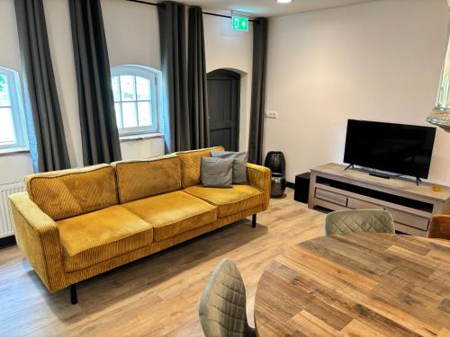 a living room with a couch and a television at Vakantiewoning Korenburgerveen 't Voorde in Winterswijk